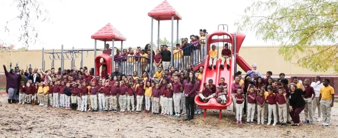 A group of children standing around a playground.